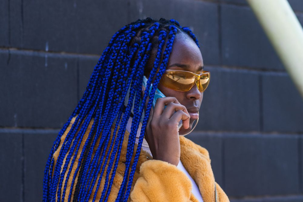 woman in trendy outfit speaking on cellphone in city