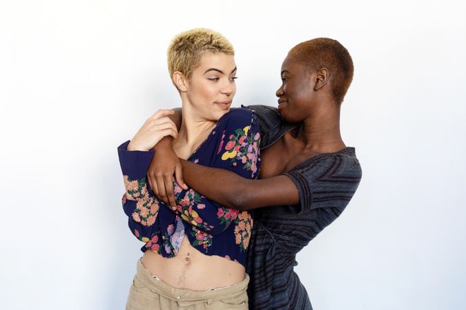 Female couple holding each other in studio space