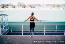 Woman in activewear overlooking a sports field o5oE9b