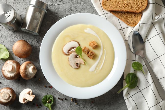 Looking down at bowl of mushroom soup on marble table