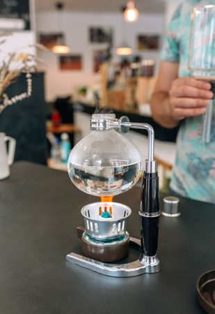 Japanese coffee maker boiling water while barista wait to put siphon and make a specialty coffee