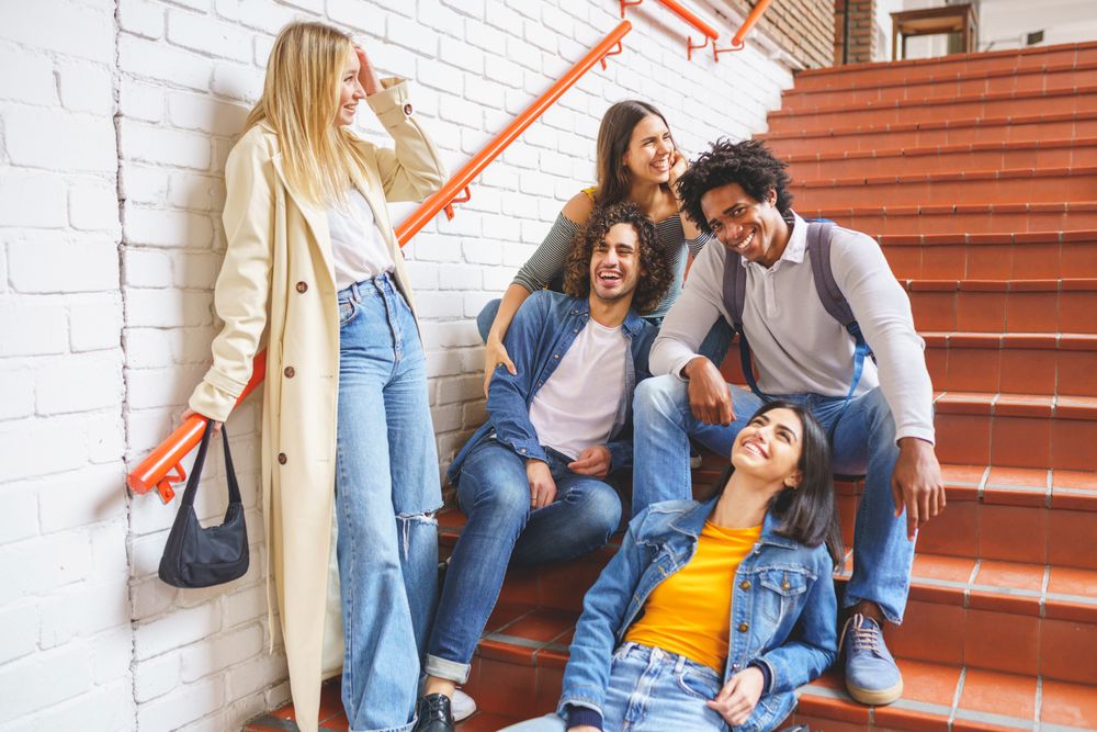 Smiling friends chatting on brick steps