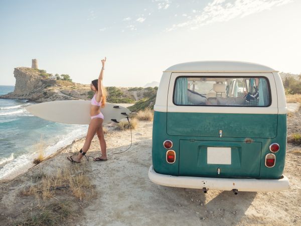 Smiling woman holding surfboard
