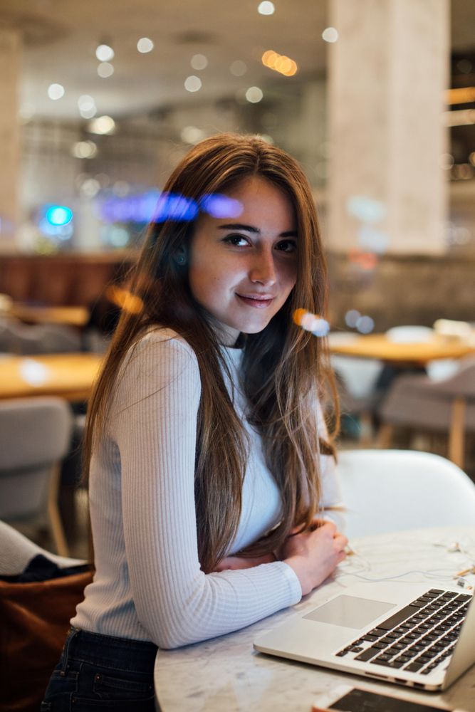 Woman looking up from laptop in a cafe