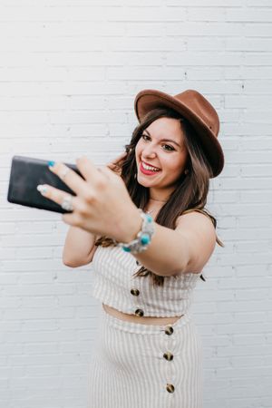 Woman smiling and taking selfie on smartphone