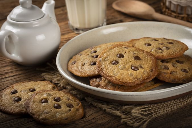 Delicious chocolate cookies with glass of milk on wooden table.