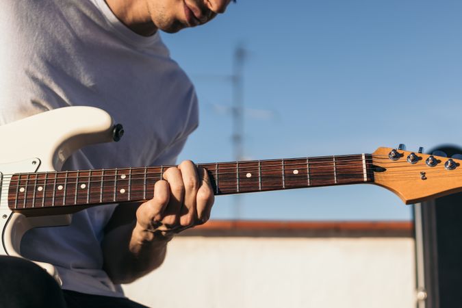 man playing electric guitar on a rooftop. close-up