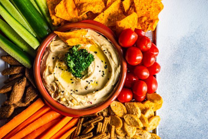 Traditional hummus dish served with cherry tomatoes and chips