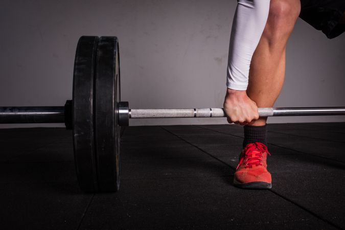 Man lifting barbell in gym