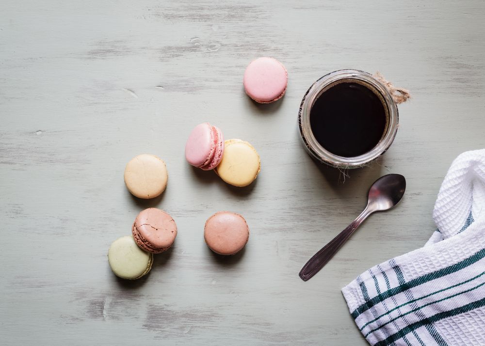 Spoon and napkin near coffee and macaroons