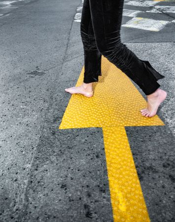Barefoot on the asphalt, with road markings