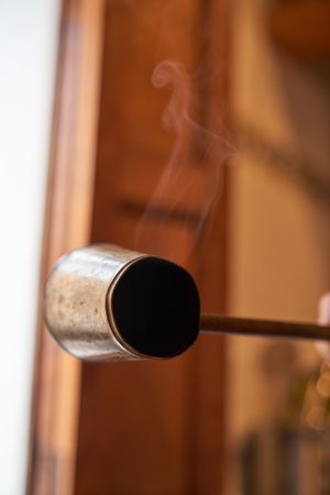 Anonymous person holding hot metal cezve