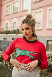 Trendy young woman near flowerbed and building