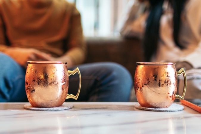Close up of two vintage style copper mugs for Moscow Mule