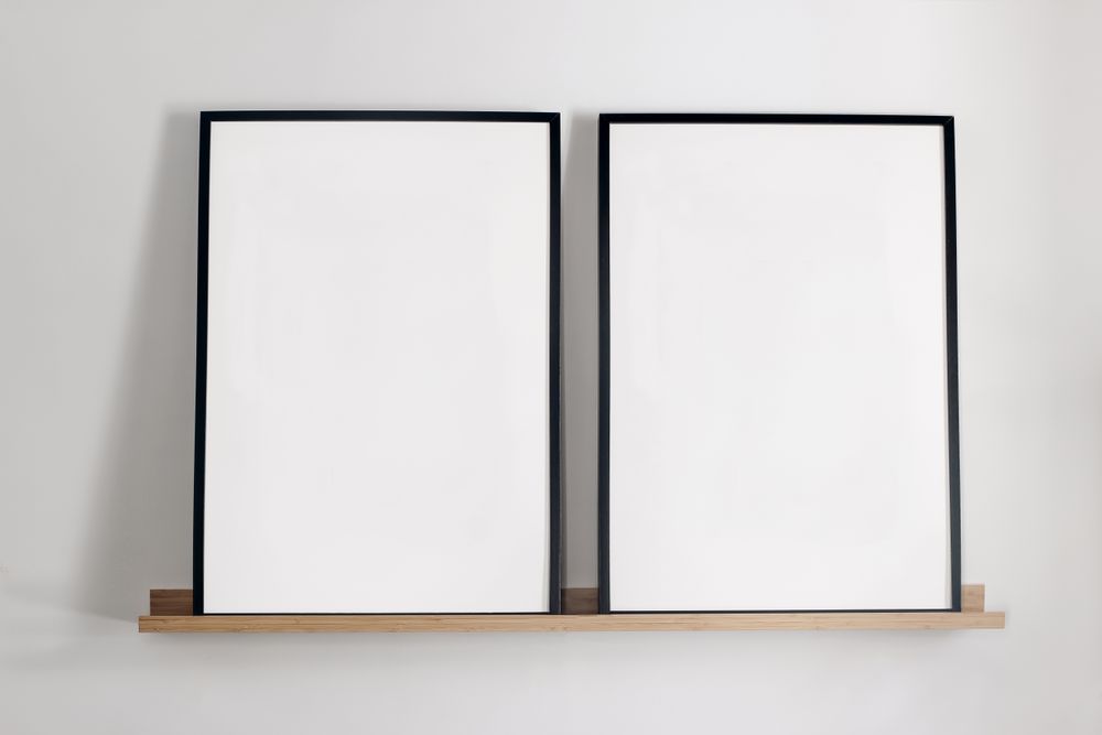 Two vertical picture frames on bamboo wooden shelf