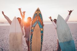 Group of young women with surf boards at the beach
