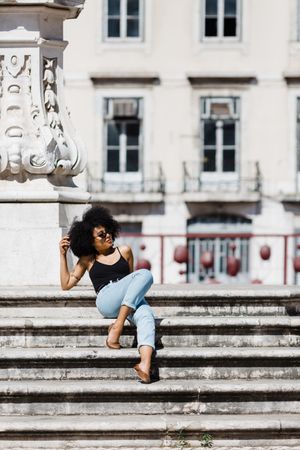 Black female sitting on stairs outdoors