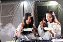 Two Female Asian  Friends Eat  Barbeque  Meat in front of Camping Tent