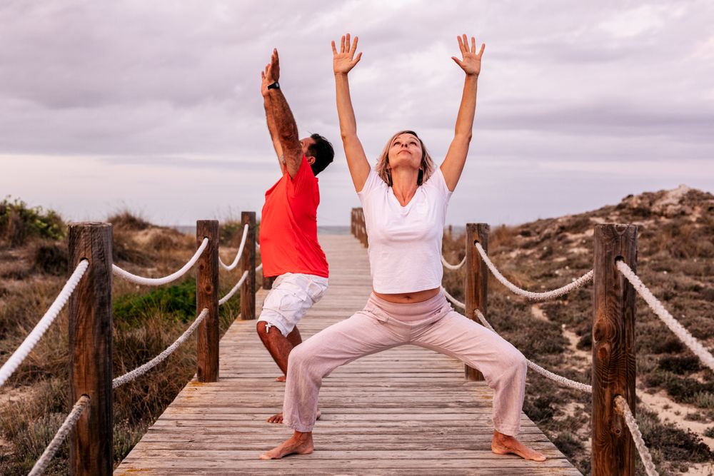 Adult couple meditating on wooden path