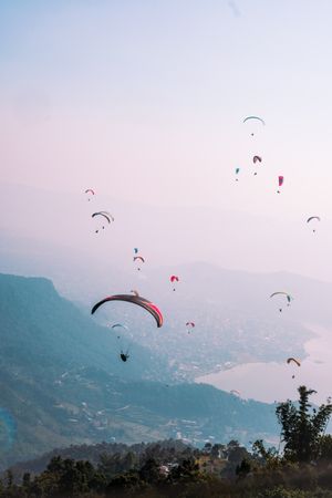 People riding parachute over mountains