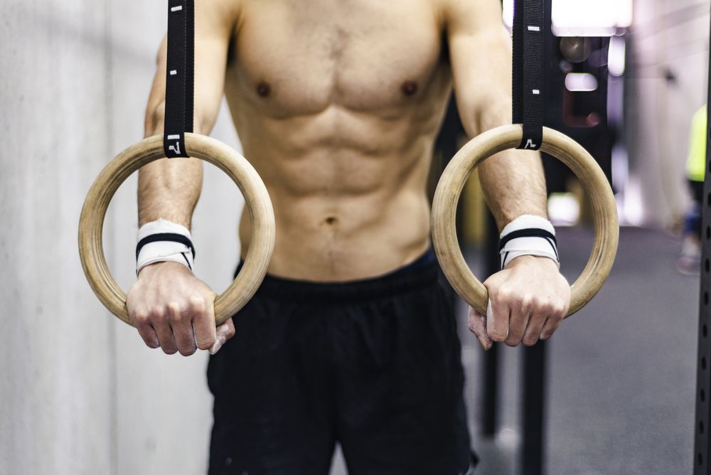 Man training with gymnastic rings in gym