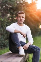 Teenager sitting on park bench looking at camera