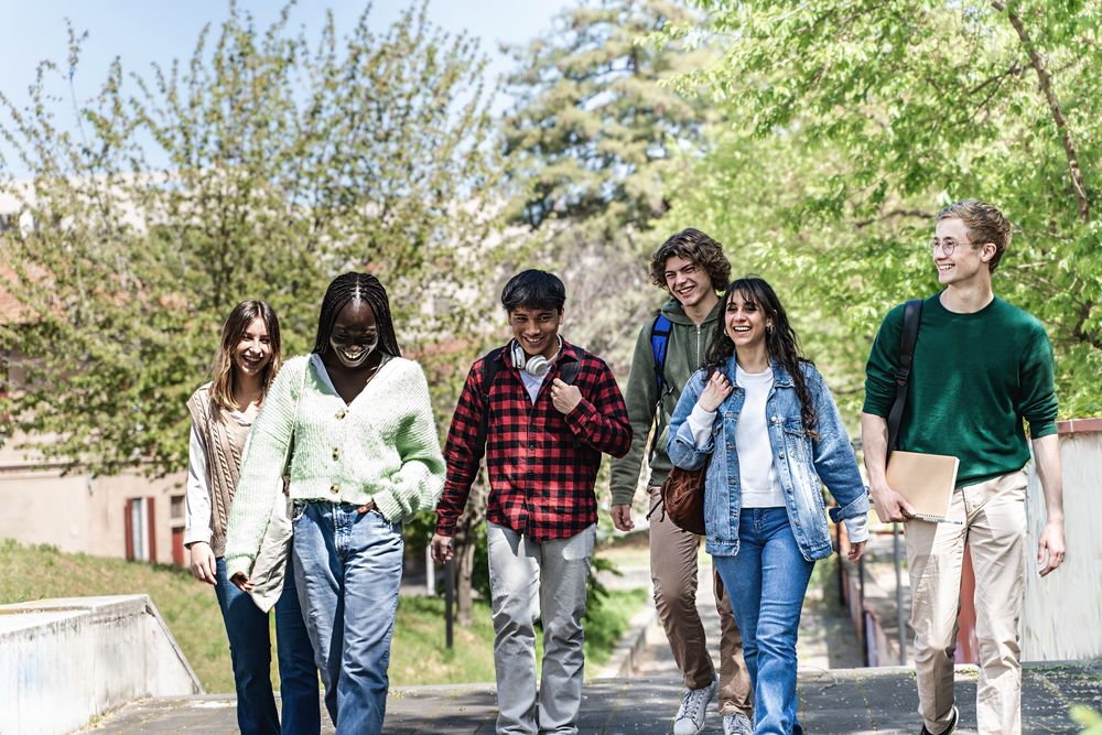 Multi-ethnic group of students walking through campus to class