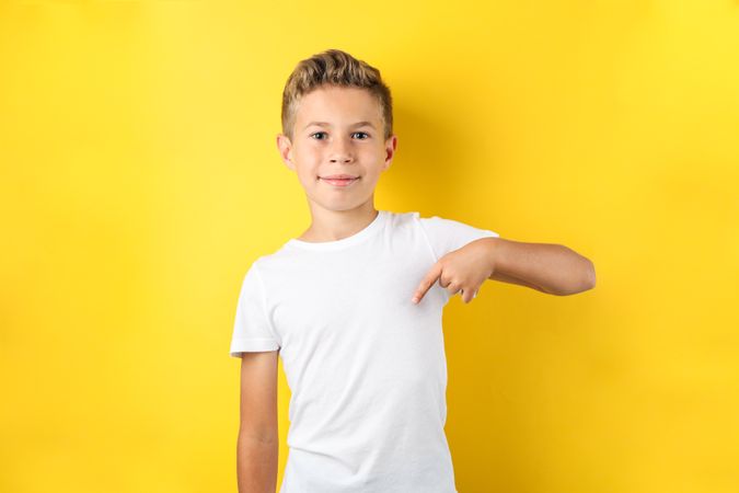 Boy in t-shirt against yellow background, space for text