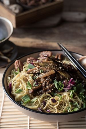 Miso noodles with egg plants and shiitake in bowl on table