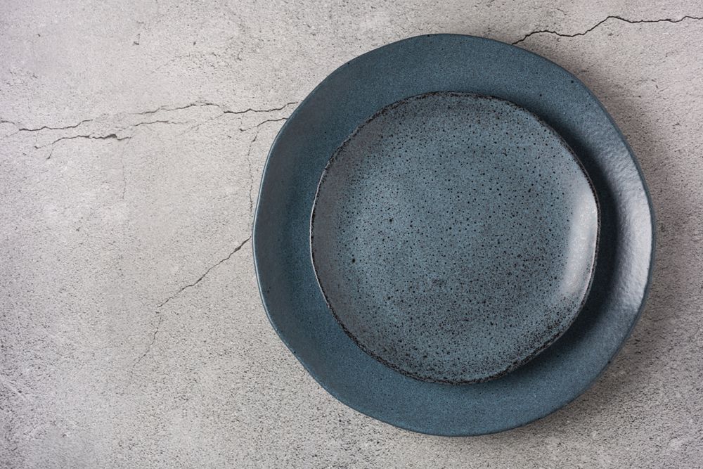 Empty plate on the slate table. Top view of the image.