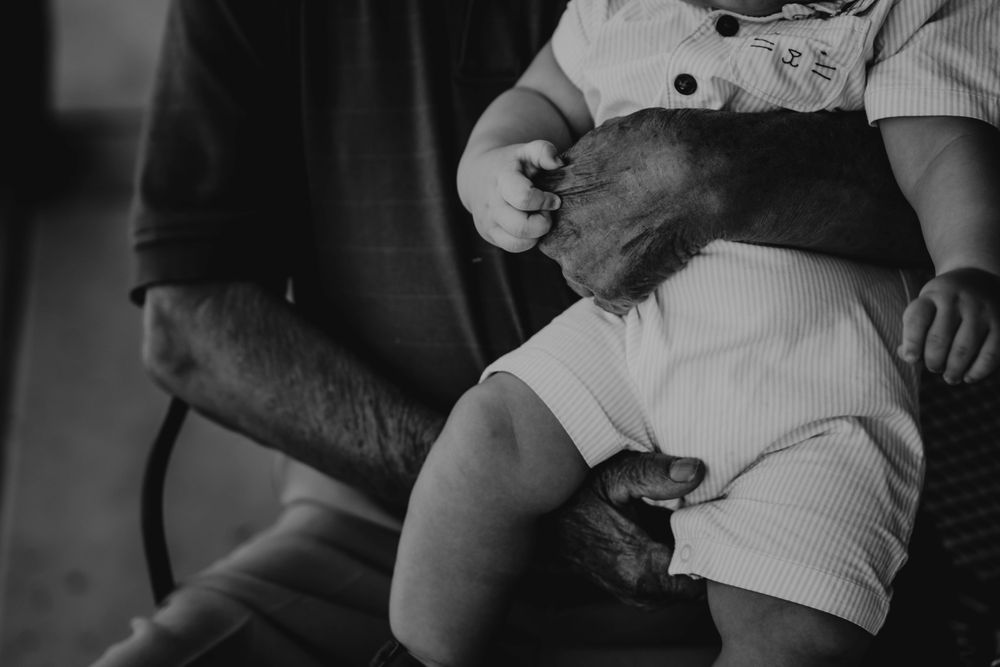 Monochrome photo of older man carrying a child