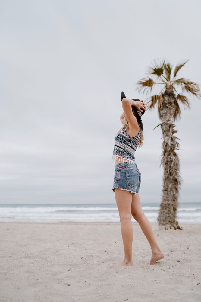 Young female relaxing on beach with hat