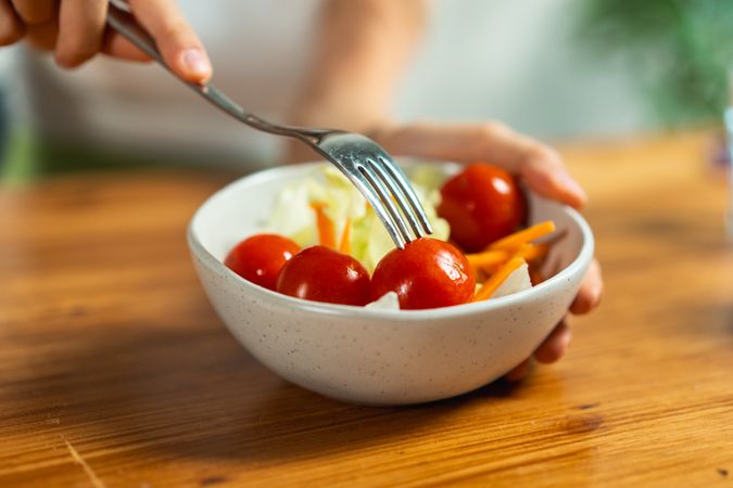 Fresh vegetable salad macro tomatoes lettuce fork eating healthy food bowl closeup nutrition diet