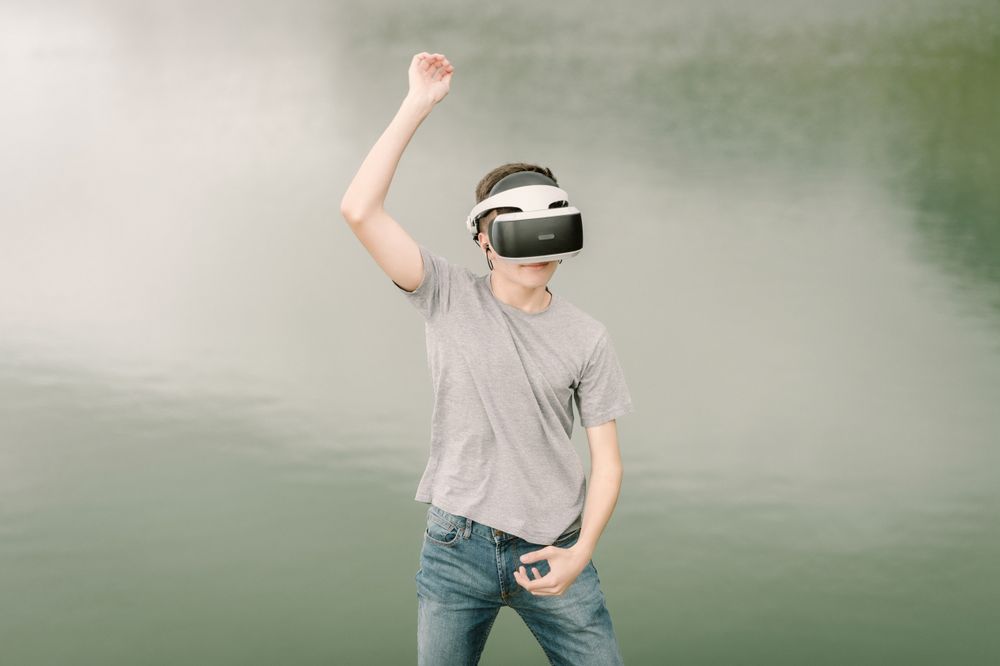 Young teenager with virtual reality glasses outdoors