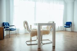 Bright office space with large windows, desk and chairs