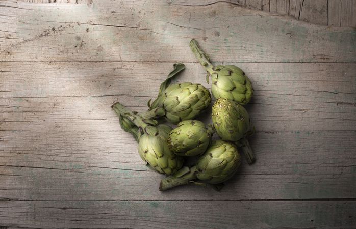 Green artichoke on wooden table