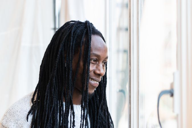 Black man looking at window on street