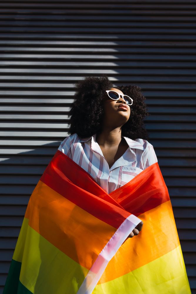 Woman posing happily with the LGBT flag