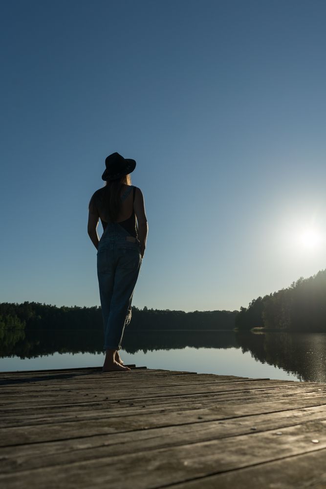 Young female standing on pier on nature