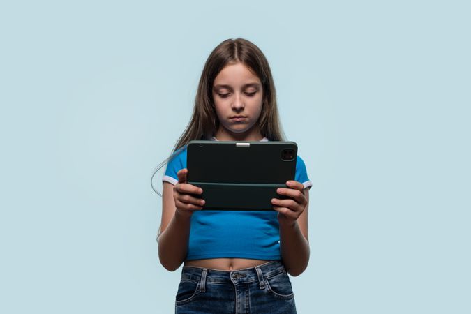 Girl looking focused and serious while using tablet