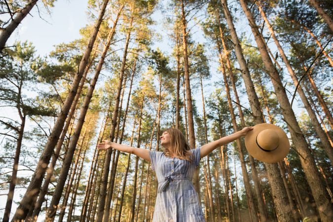 Smiling young woman relaxing among pine trees
