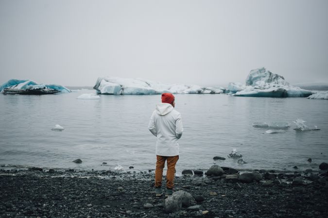 Man looking out at coast with glaciers