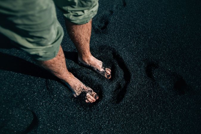 Legs of man standing on beach