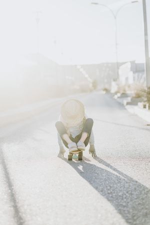 Stylish girl with skateboard on street