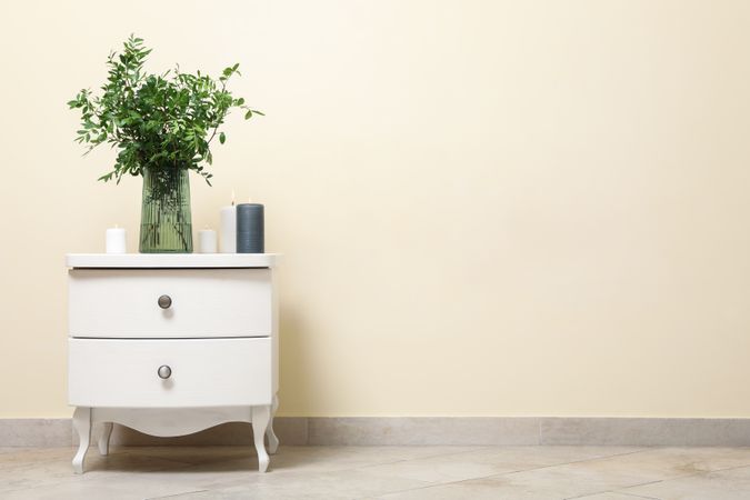 Nightstand with vase with plant and candles