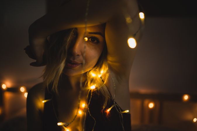 Woman surrounded with light garland