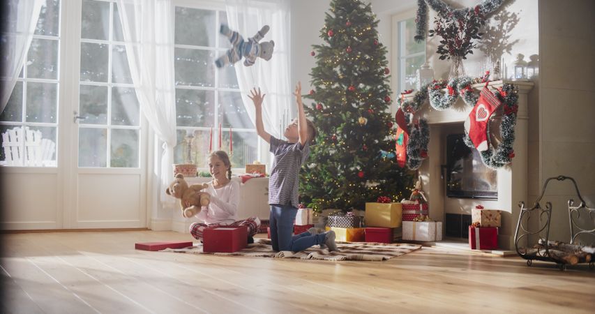 Happy Little Boy and Girl Waking Up on Holiday Morning to Receive New Toys