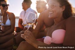 Close up of woman wearing bikini and drinking rosé wine beeNlb