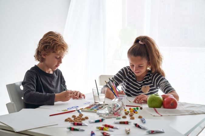 Children painting at messy table