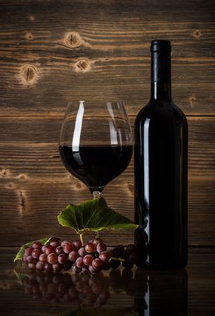 Wine concept with glass, grapes, cork & barrel